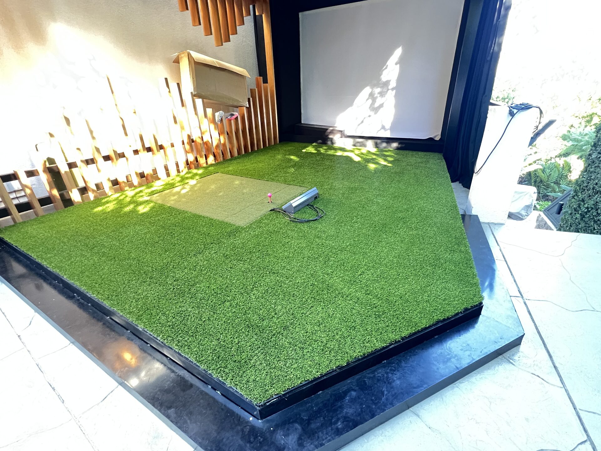 Continuous artificial turf and putting green across the golf simulator platform